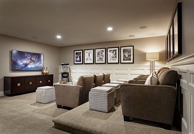 Home theater with lounge chairs, popcorn machine, and football on the television