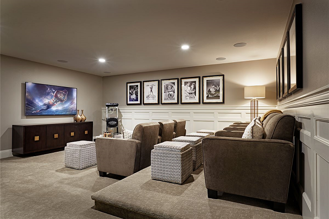 Theater room with two rows of lounge chairs facing a television