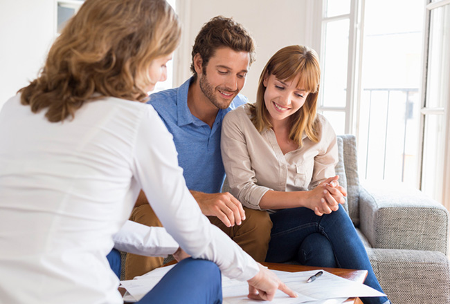 Couple and real estate agent reviewing paperwork