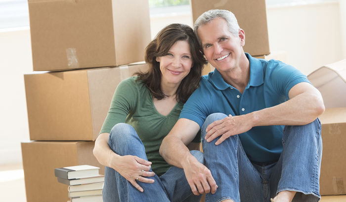 Home in Five: Smiling couple in front of moving boxes