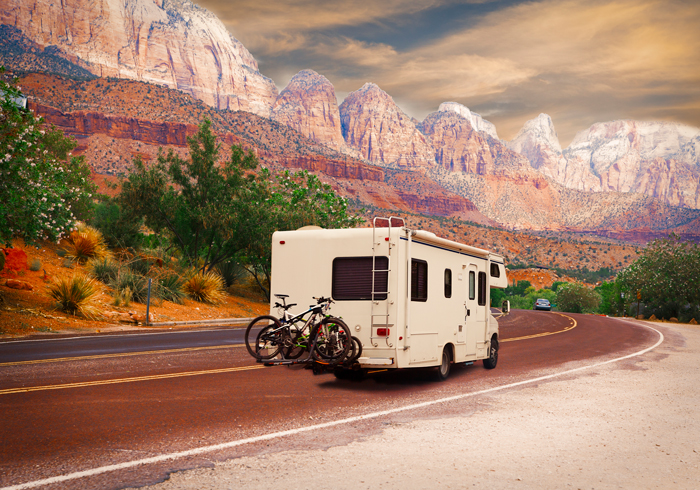 RV driving through scenic area with red rocks