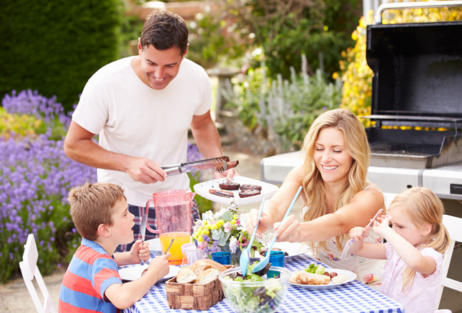 Family of four enjoying a backyard barbeque
