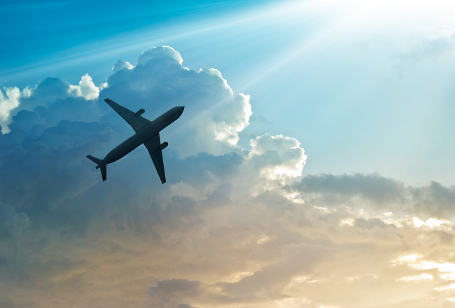 Airplane flying across a cloudy sky