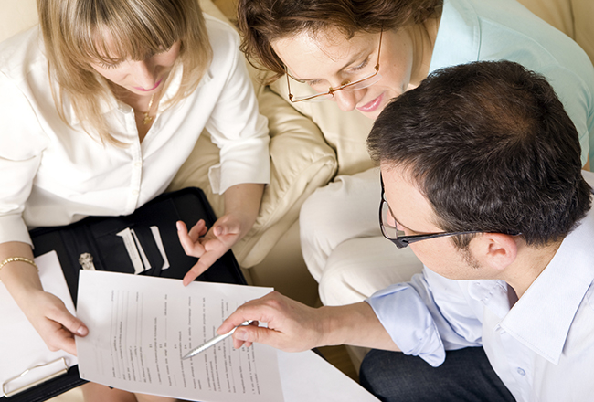 Three people looking at financial paperwork