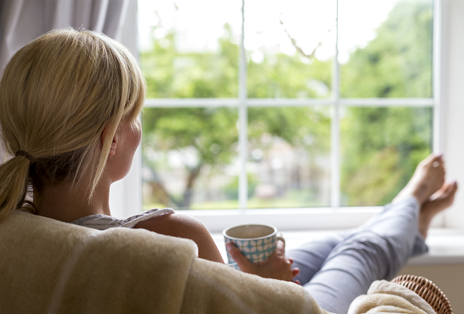 Woman relaxing on couch and gazing out the window