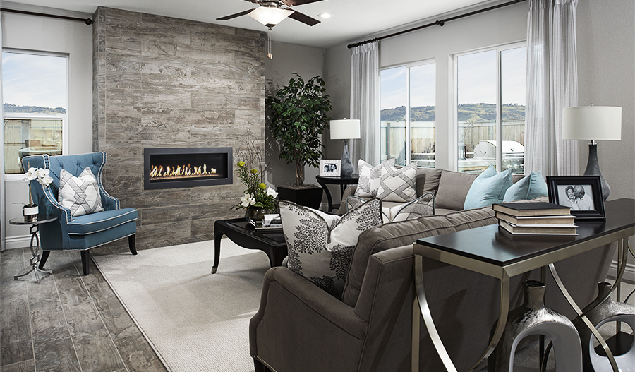 Lighted ceiling fan and lamps in great room with fireplace