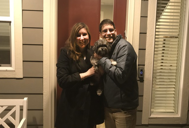 Couple with their dog outside of new home