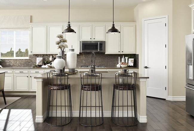 Kitchen with Fresnel pendant lights hanging over island with barstools