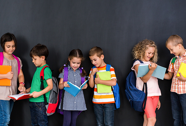 Row of children looking at books