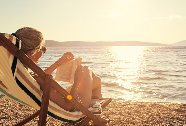 Woman reading book on the beach