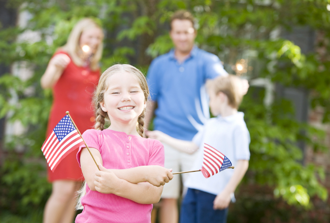 Family with little girl holding American flags