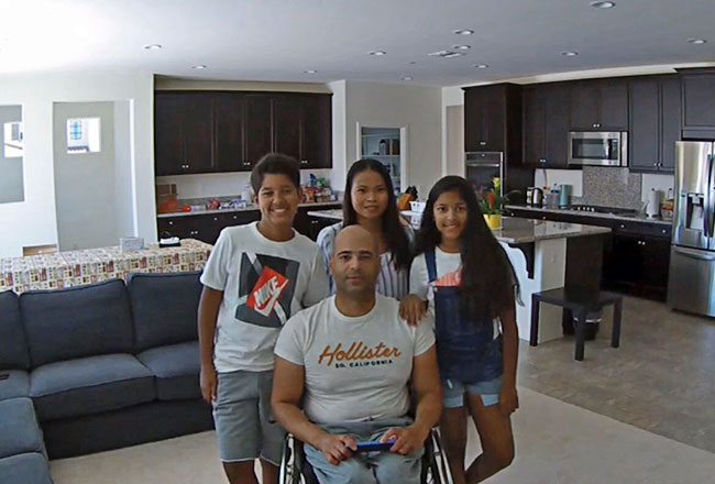 man in wheelchair with his family in great room