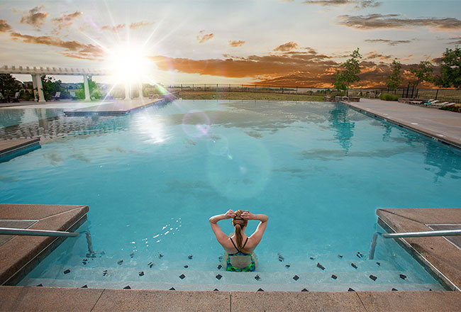 Woman sitting on steps of community swimming pool