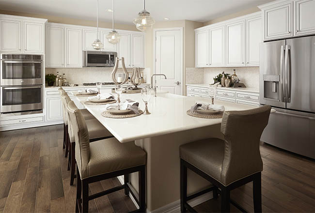 Kitchen with white cabinets and center island with place settings