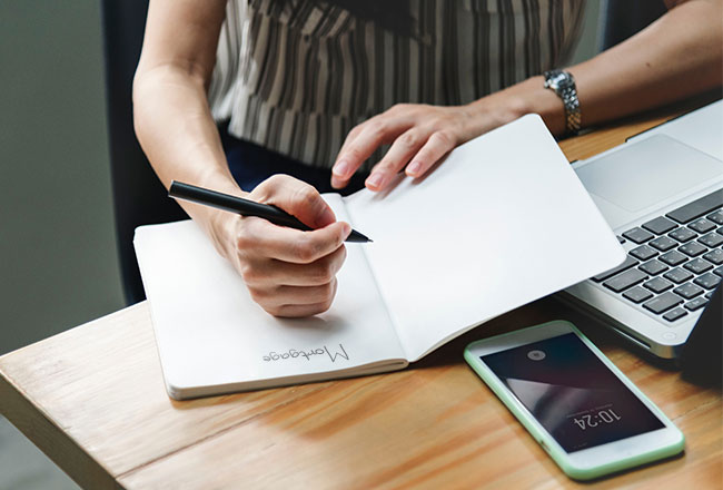 Woman making mortgage notes in notepad