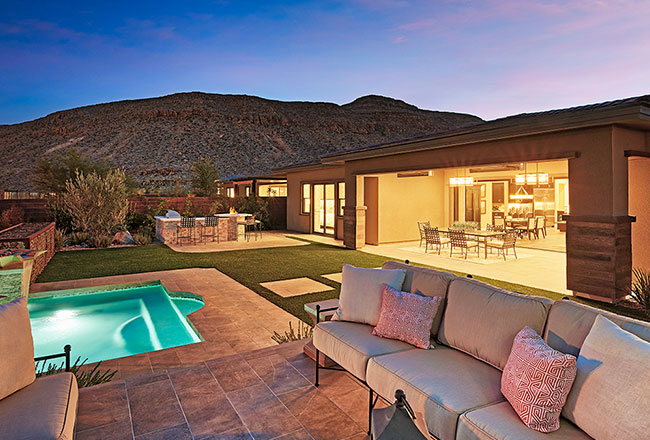 Backyard with seating and pool at night