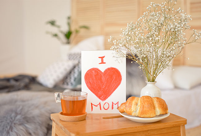 Breakfast in bed with tea, croissant and I love mom card