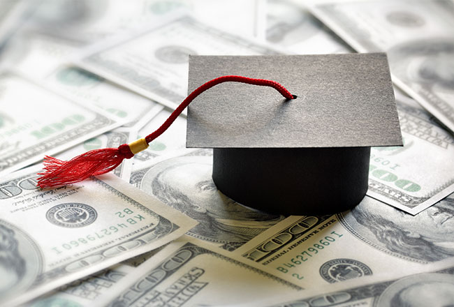 graduation cap sitting on top of $100 bills