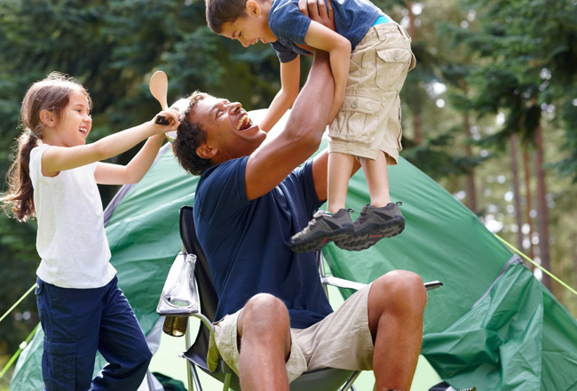 Father holding young son in air