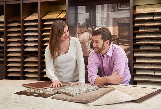 Couple looking at carpet, cabinet and countertop samples at design center