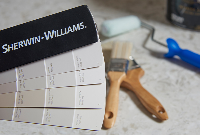 Book of paint swatches and paint brushes lying on counter