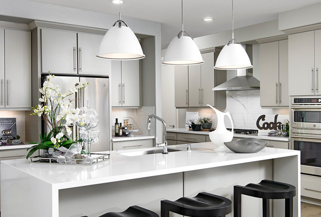 Kitchen with dark stools and white cabinets, island and light fixtures 