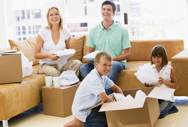 Parents and young child unpacking moving boxes