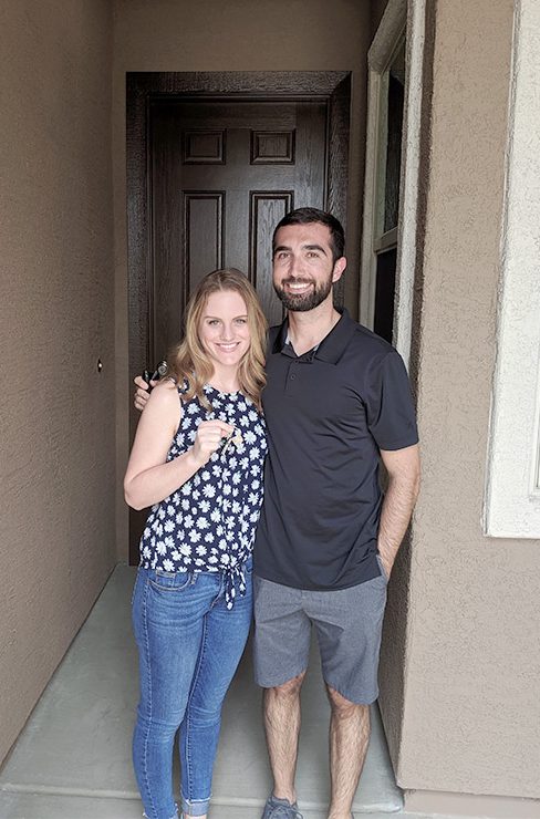 Couple standing in covered entry of their home