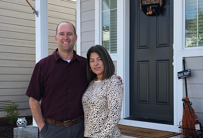 Couple standing in front of their front door