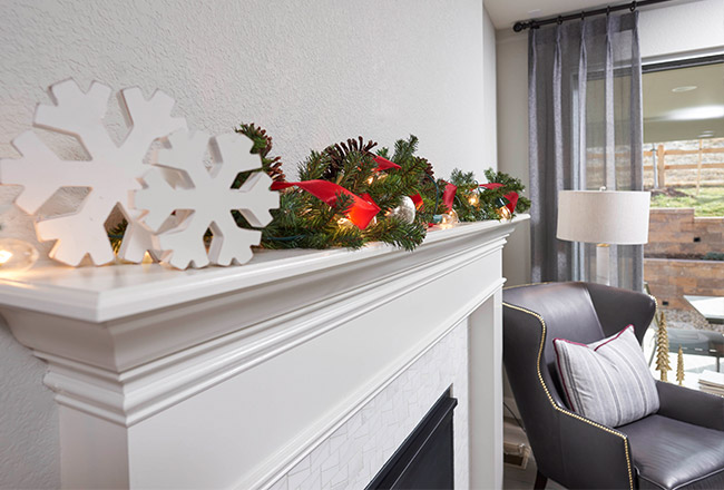 Close up of holiday décor sitting on top of white fireplace