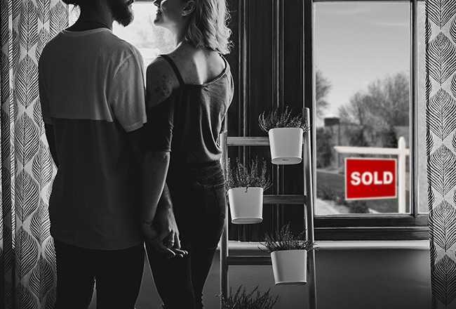 Couple holding hands by window, red sold sign visible outside