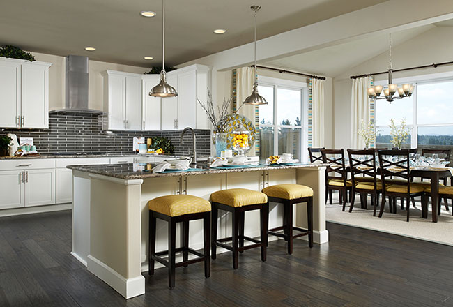 Kitchen with white cabinets and dark countertops and backsplash