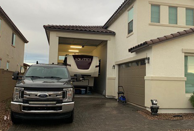 Exterior of home with truck parked on driveway and boat parked in RV garage