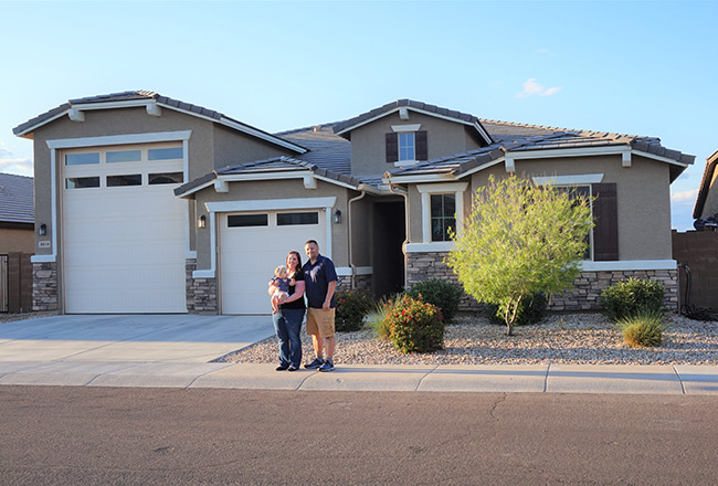 Family standing in front of their two-story Deacon home