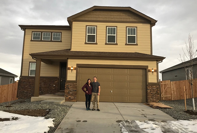 Couple standing in driveway of new home