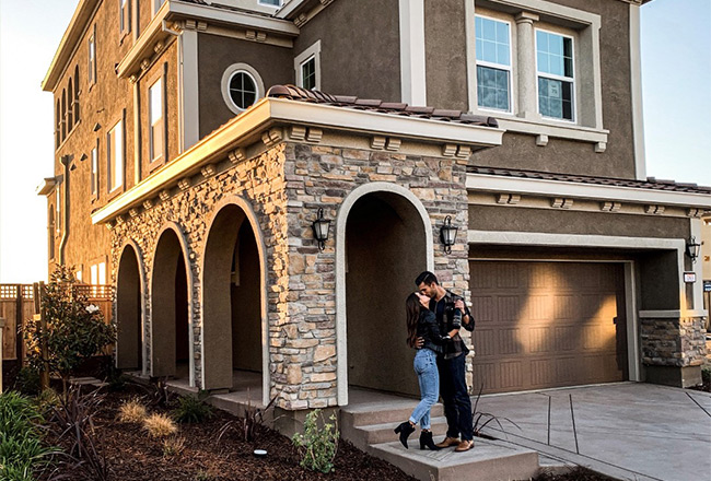 Couple kissing on front porch of new home