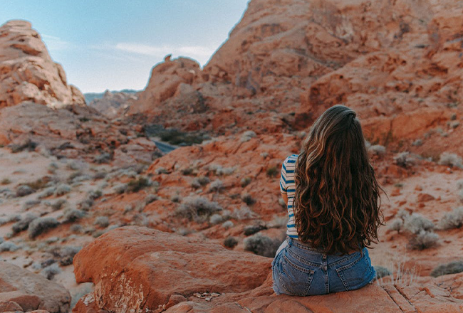 Back of women sitting in the desert