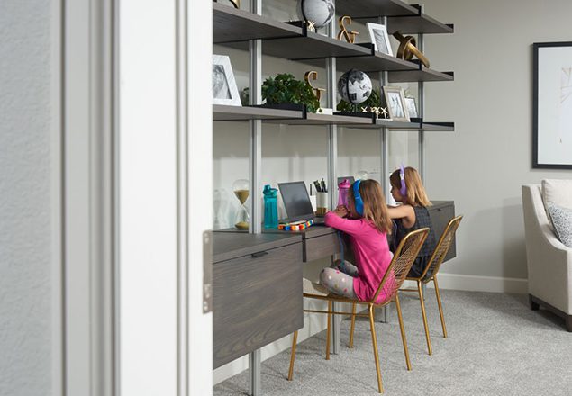 Two young girls doing virtual learning with headphones on at home