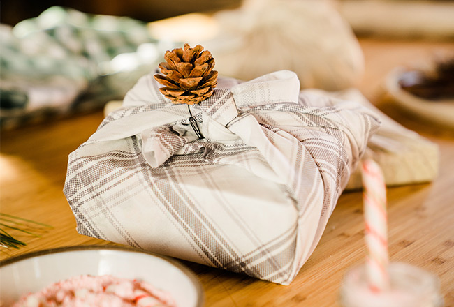 Wrapped gift adorned with a pine cone