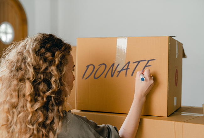 Woman writing donate on a box