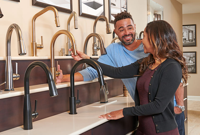 Man and woman looking at several faucet options