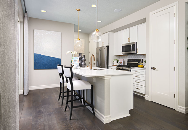 Kitchen with island with two chairs, pantry, white cabinets, and stainless steel appliances