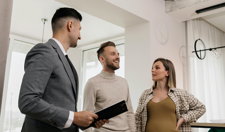 Couple talking to Richmond American Homes sales associate in front of dirt lot