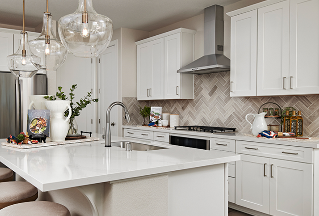 Kitchen island and neutral herringbone tile backsplash