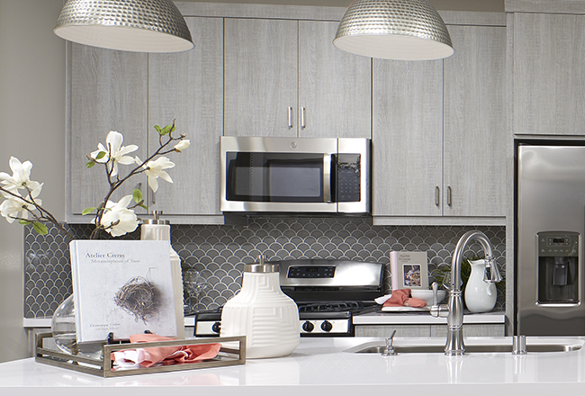 Kitchen island and gray curved mosaic tile backsplash with white grout