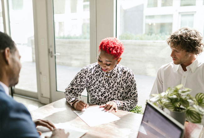 Couple signing contract with real estate agent