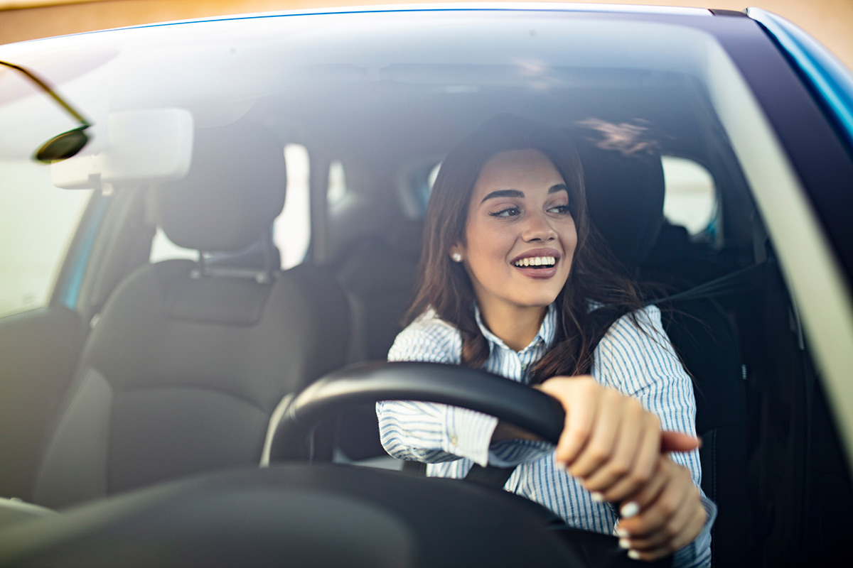 Woman behind the steering wheel of a car.