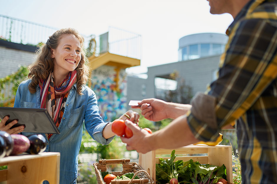 Smiling woman buying tomatoes at farmer's market