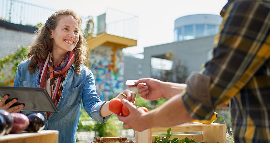 Smiling woman buying tomatoes at a farmer's market