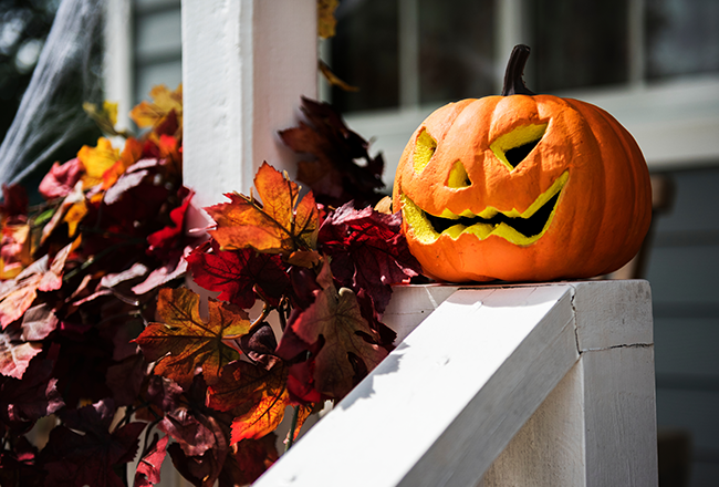 Jack O' Lantern sitting on porch railing